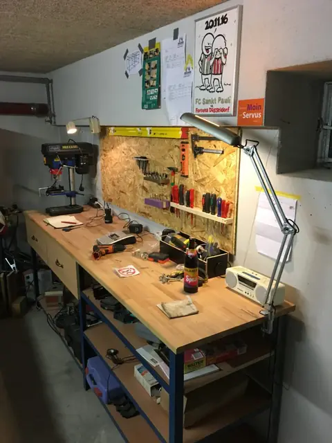 Werkbank mit Werkzeugwand, Ständerbohrmaschine und Arbeitslampe